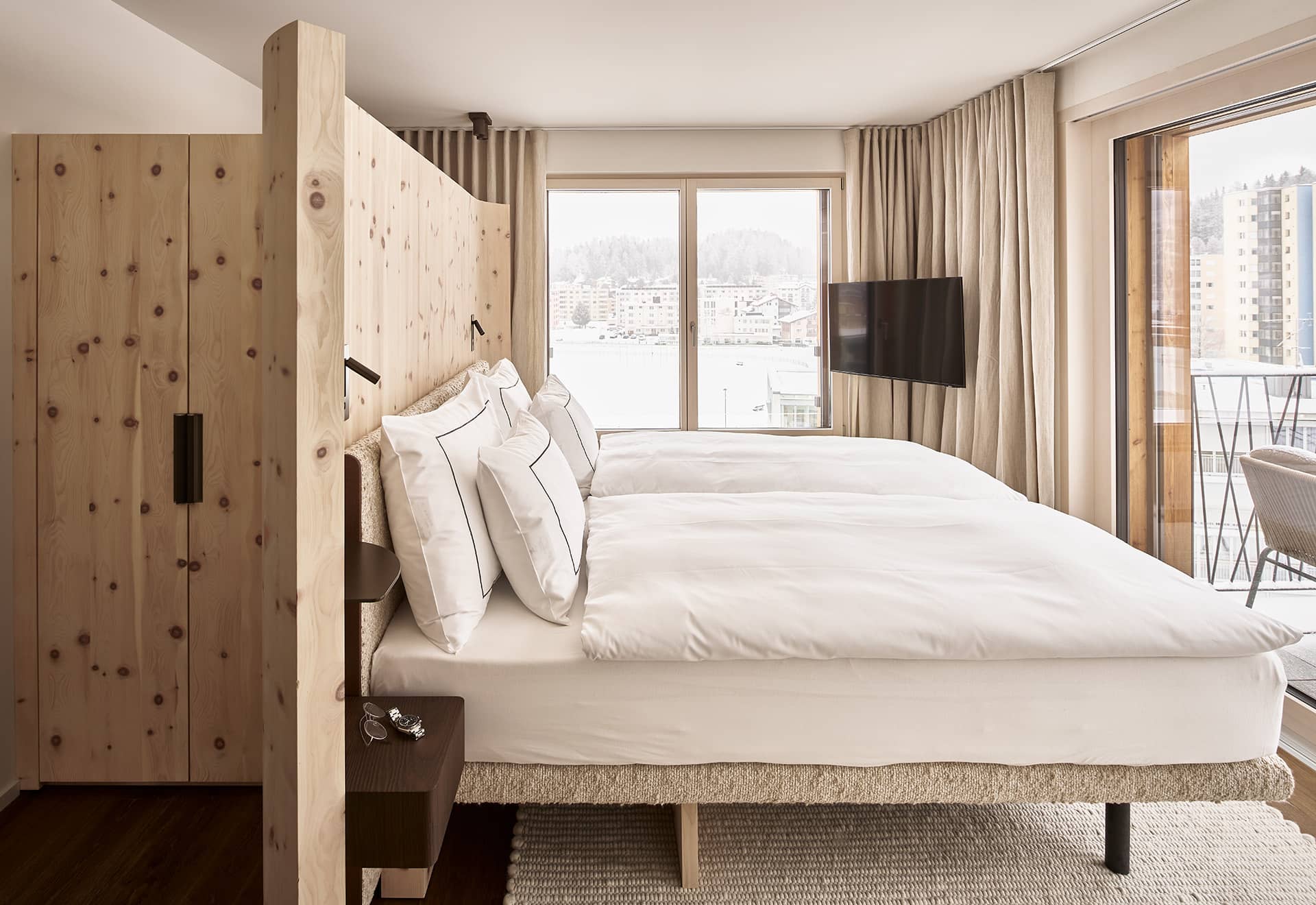 Schlafzimmer im Penthouse mit Doppelbett, Balkonzugang und Blick nach draußen