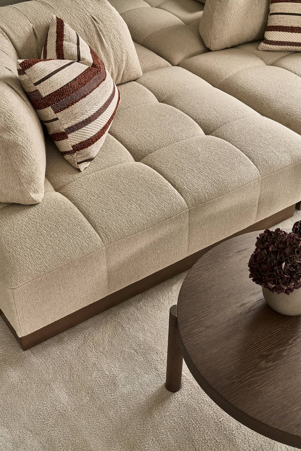 Detailansicht des Sofas im Wohnbereich mit strukturierter Polsterung und Kissen