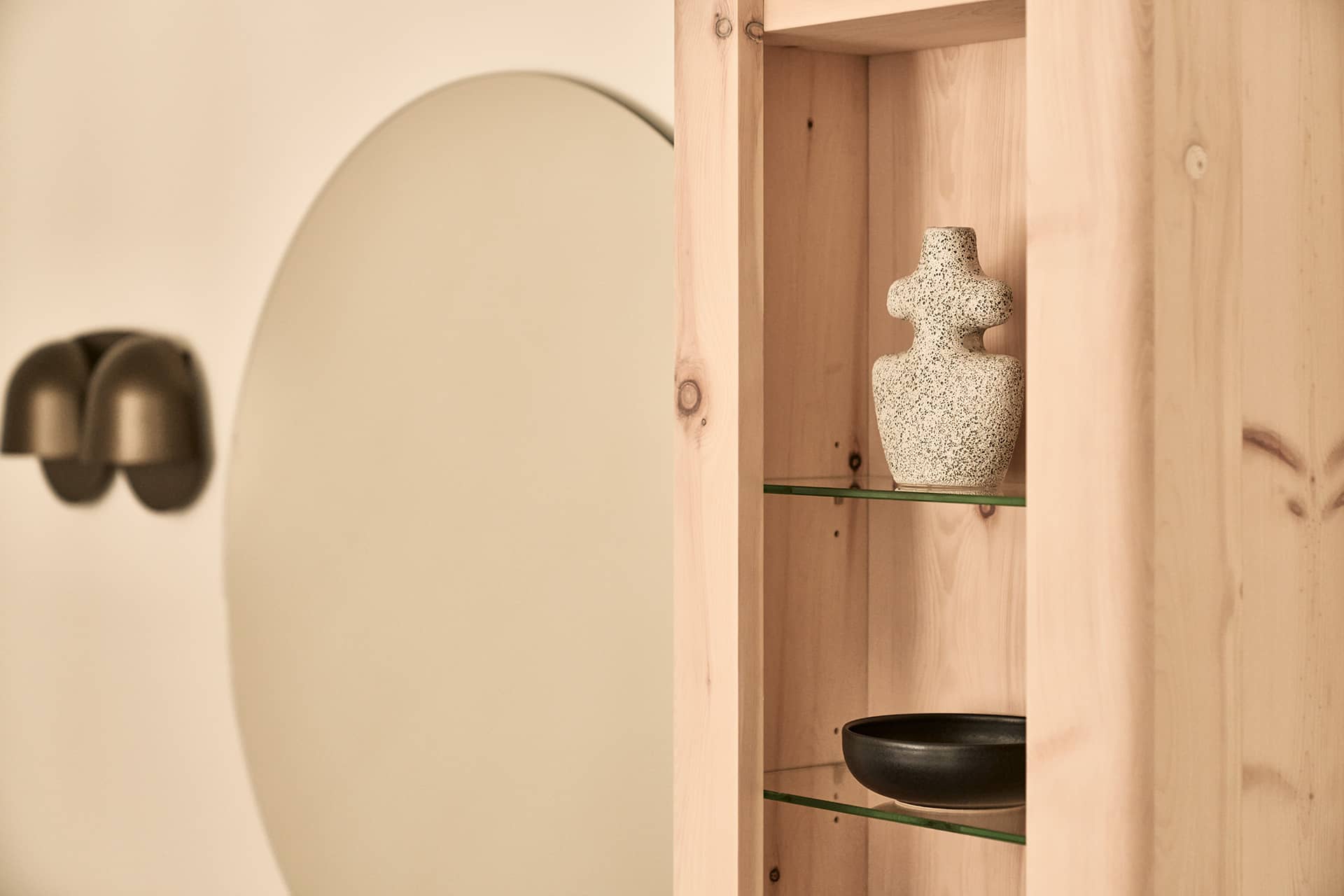 Dekoratives Wandregal im Penthouse mit Keramikobjekten und Spiegel