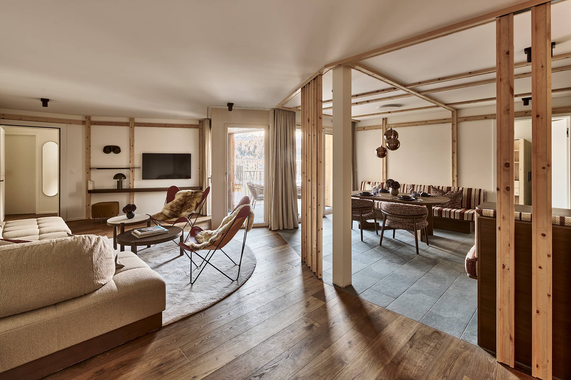 Großzügiger Wohn- und Essbereich der Premium Suite mit Lounge, Esstisch und Raumtrennern aus Holz