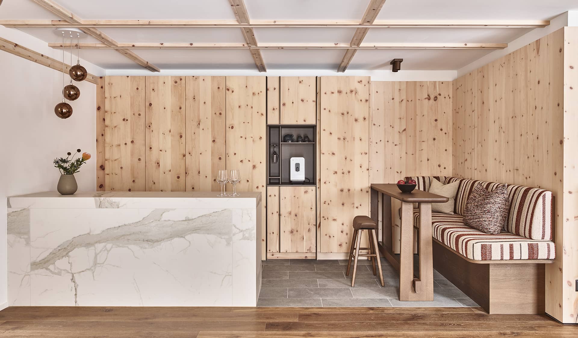 Küchenbereich der Residence 2 mit Kochinsel, Naturholzfronten und Sitzbank