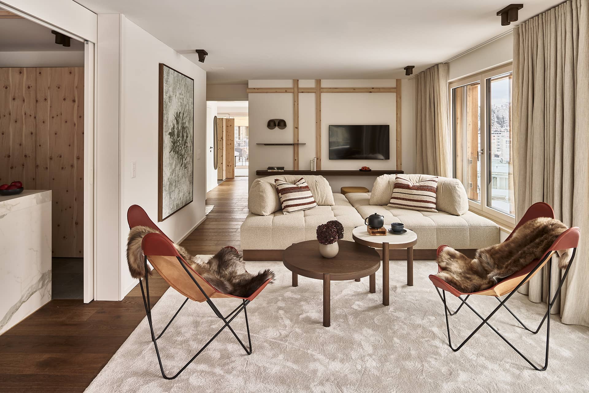 Wohnbereich der Residence 3 mit Sofa, Lounge-Sesseln und TV-Wand