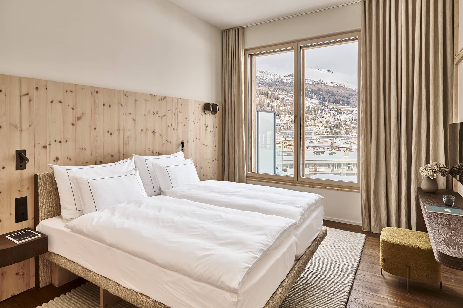 Modernes Doppelzimmer im Masterpenthouse mit Arvenholz, großen Fenstern und winterlichem Bergblick